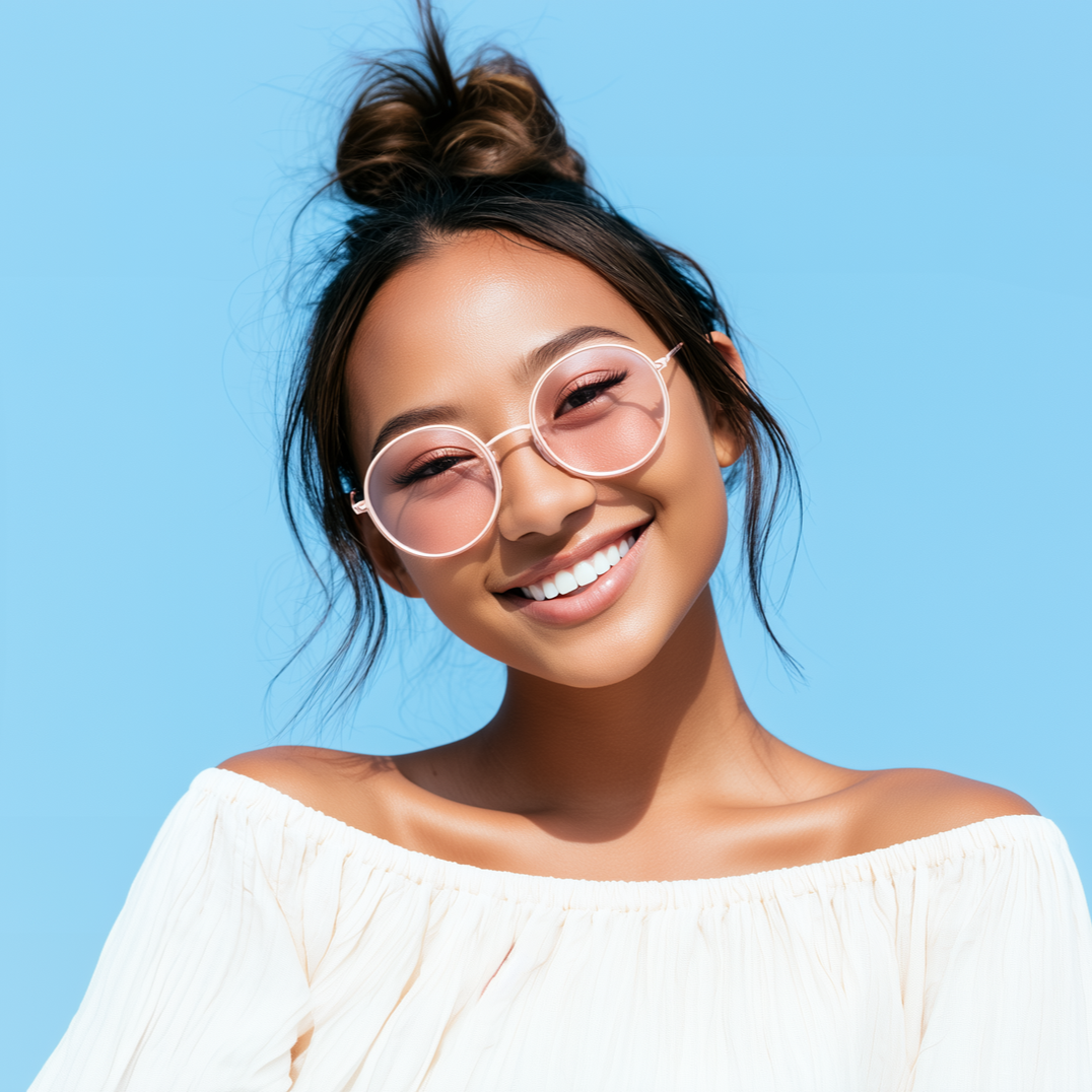 Smiling woman with pink glasses and white off-shoulder top against a blue background