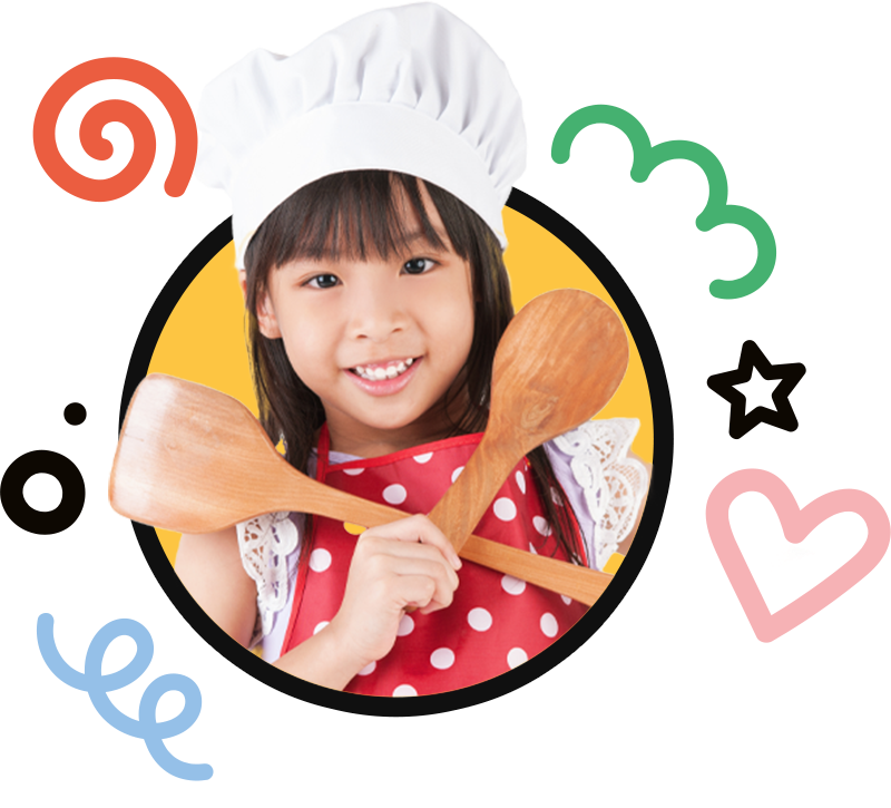 A little girl wearing a chef hat is holding two wooden spoons