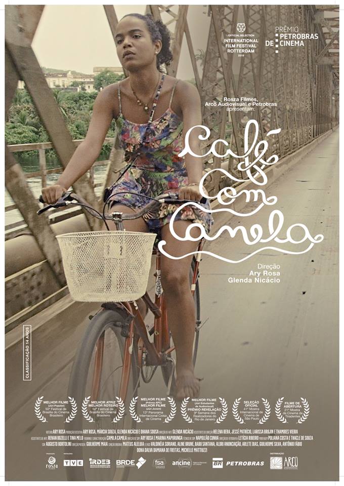 Uma mulher está andando de bicicleta em uma ponte.