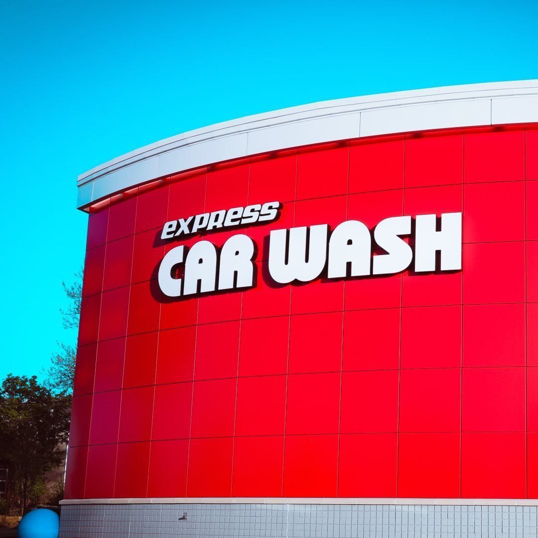 A black car is being washed in a car wash.