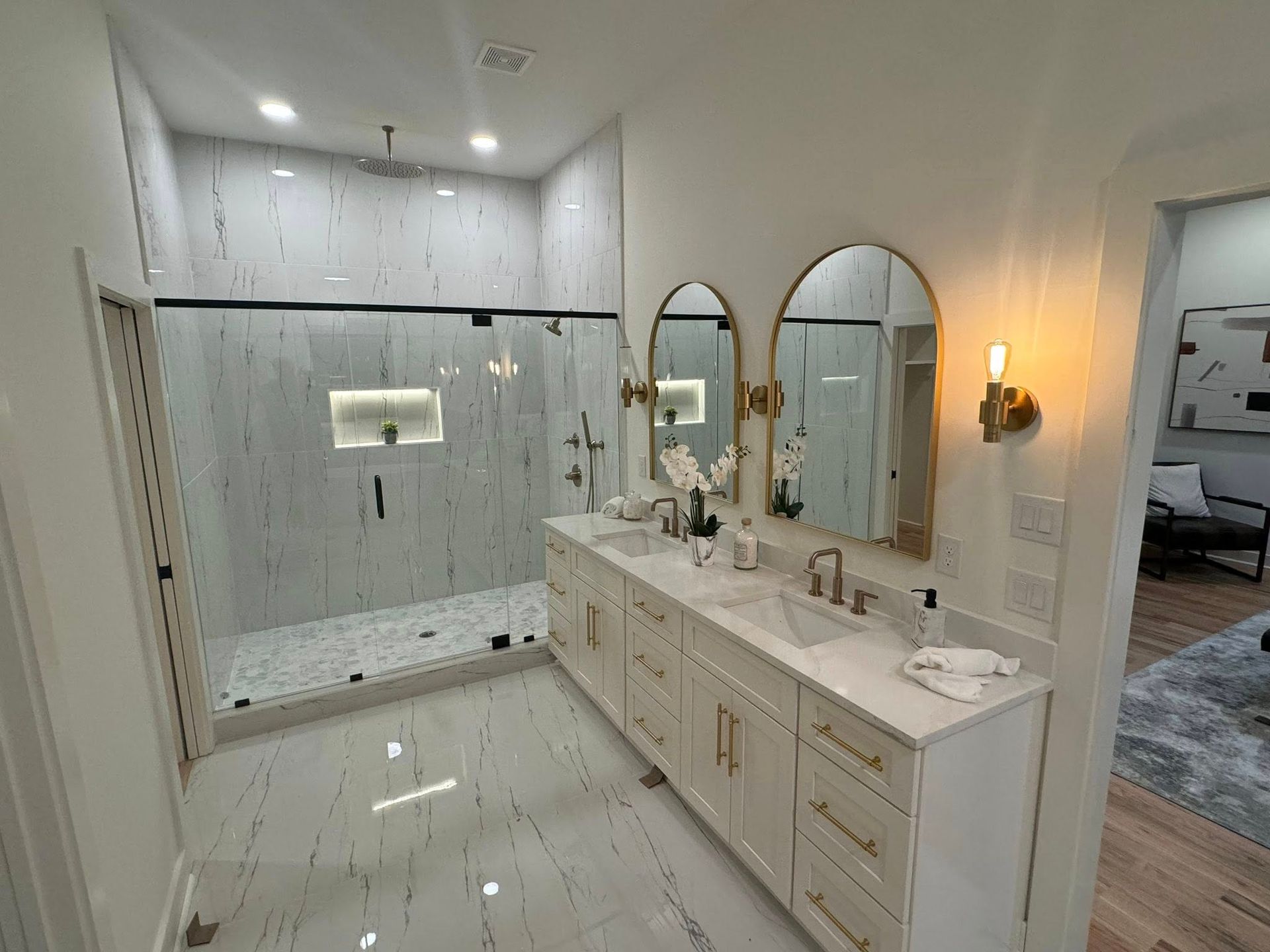 A bathroom with two sinks and a walk in shower.