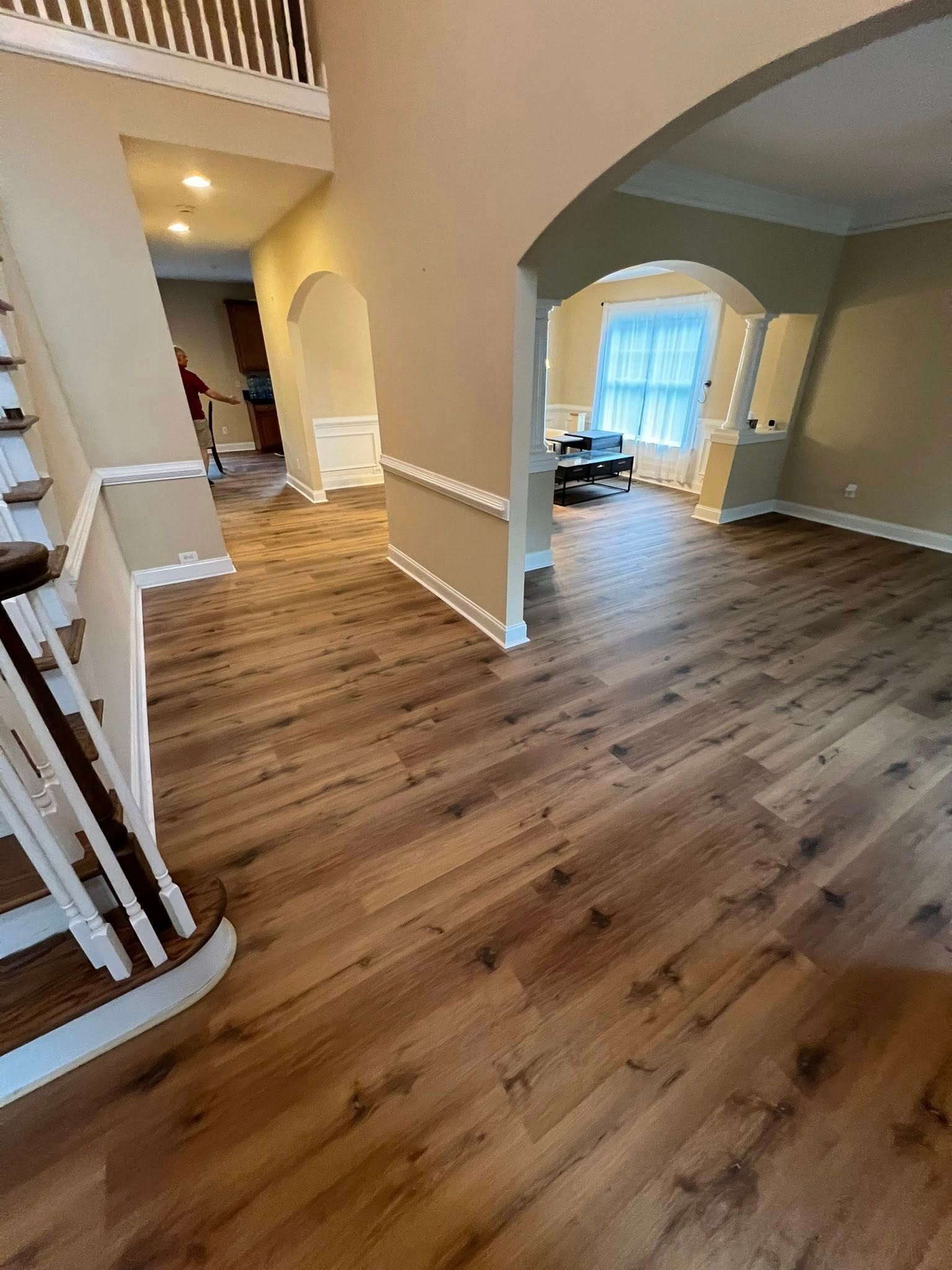 A living room with hardwood floors and stairs in a house.