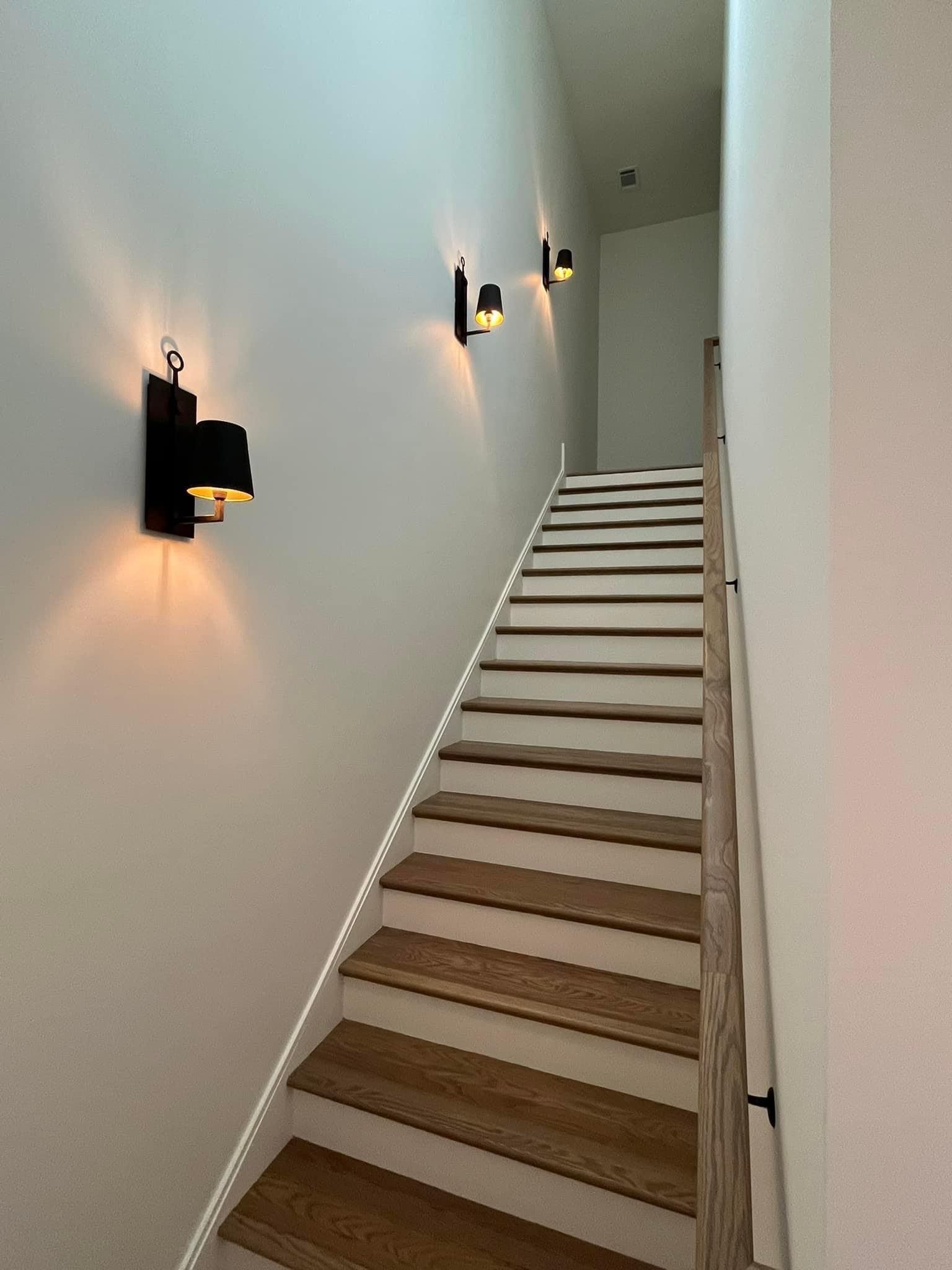 A staircase with wooden steps and a wooden railing leading up to the second floor.