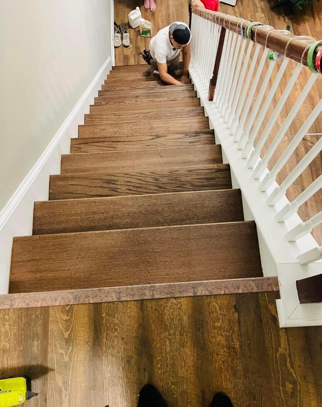 A man is kneeling down on a set of wooden stairs.