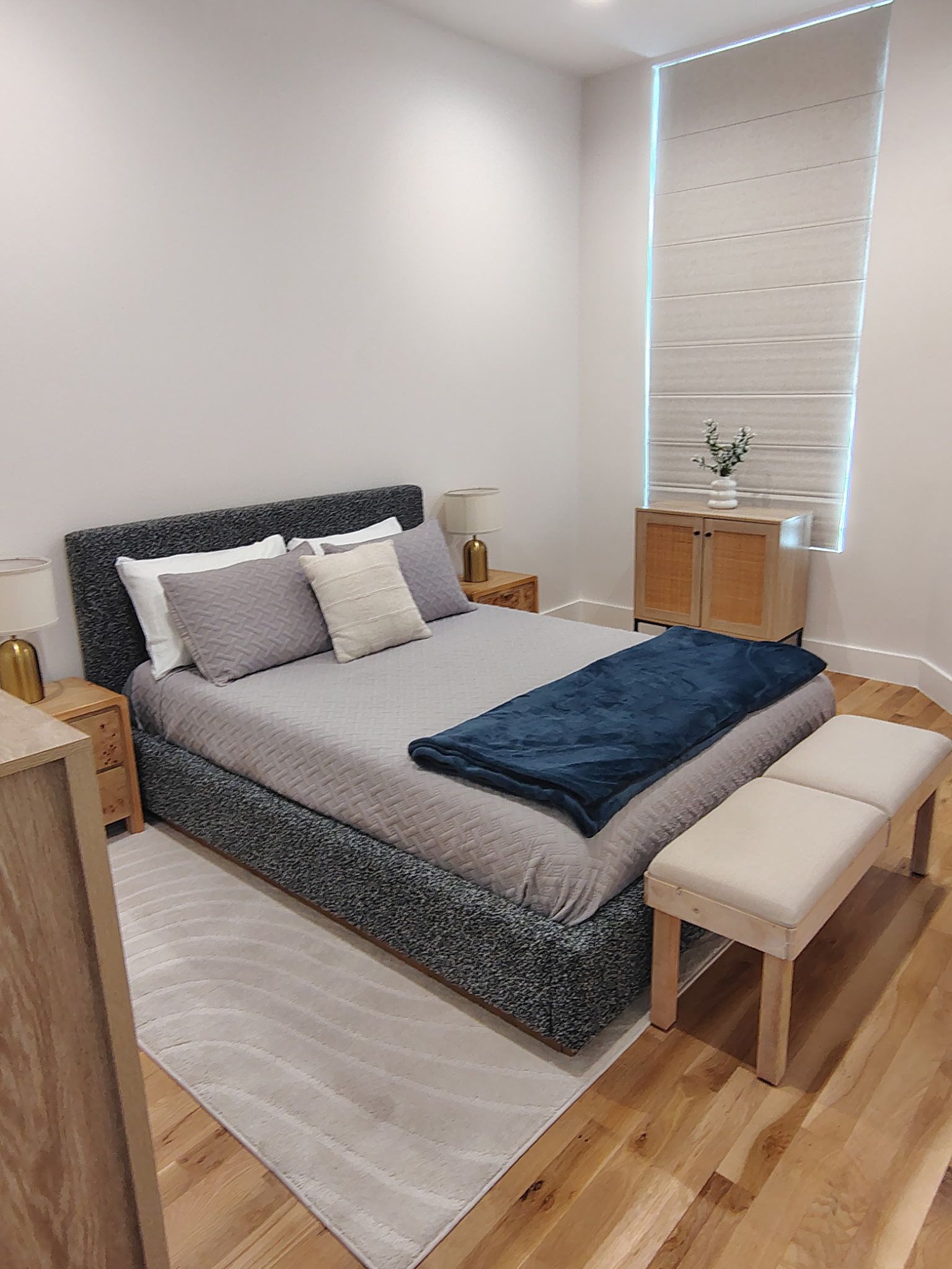 Bedroom with a bed, nightstands, rug, window, dresser, and a bench.