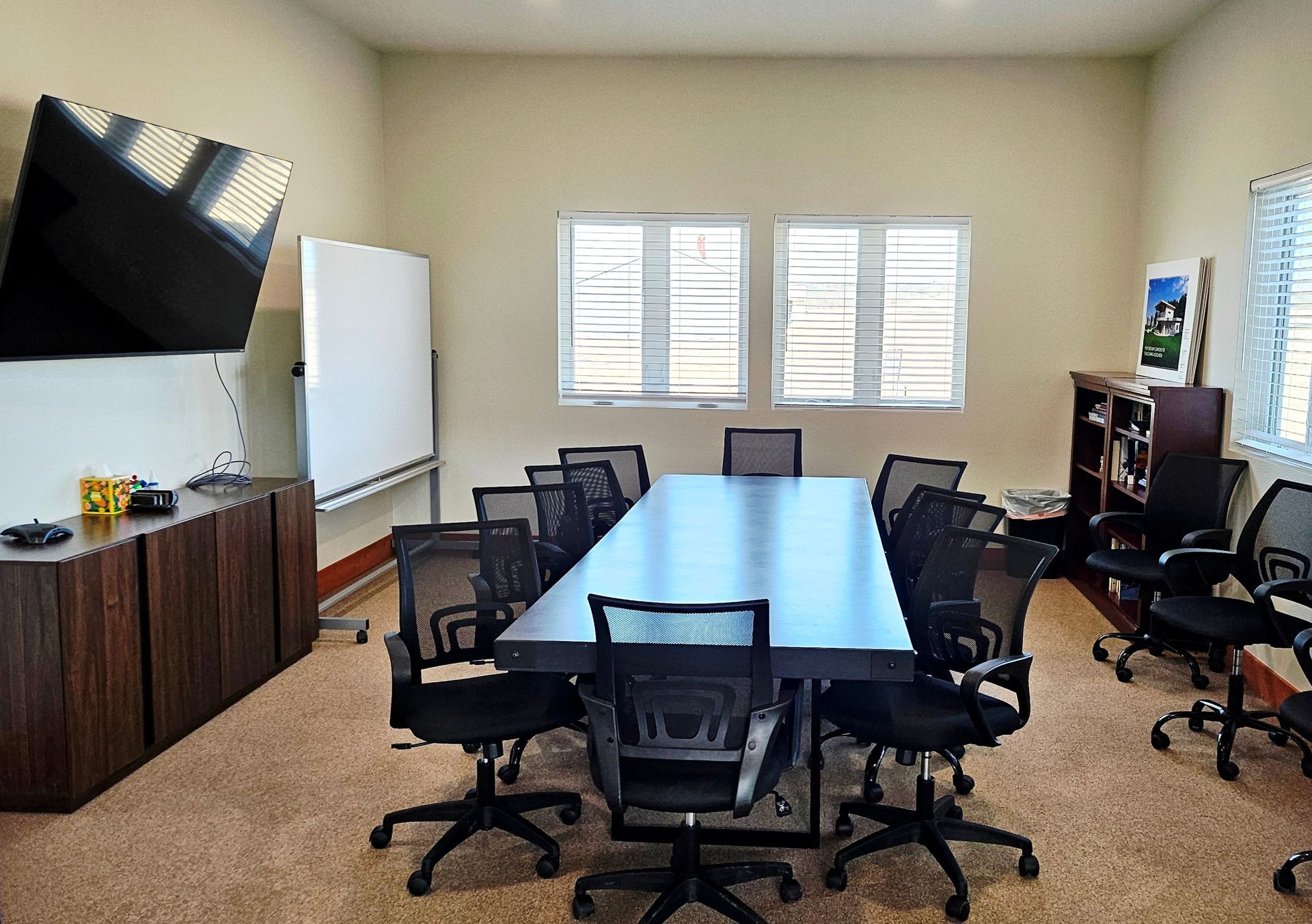Office cleaners cleaning a modern office. People in blue shirts, cleaning desks, mopping, and vacuuming.