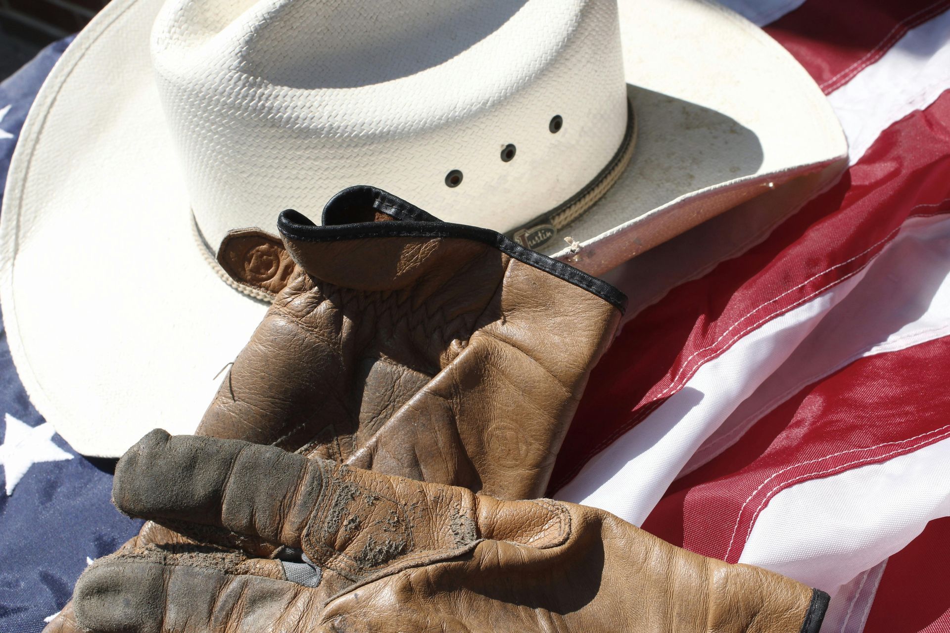 Cowboy hat and leather gloves on an American flag.