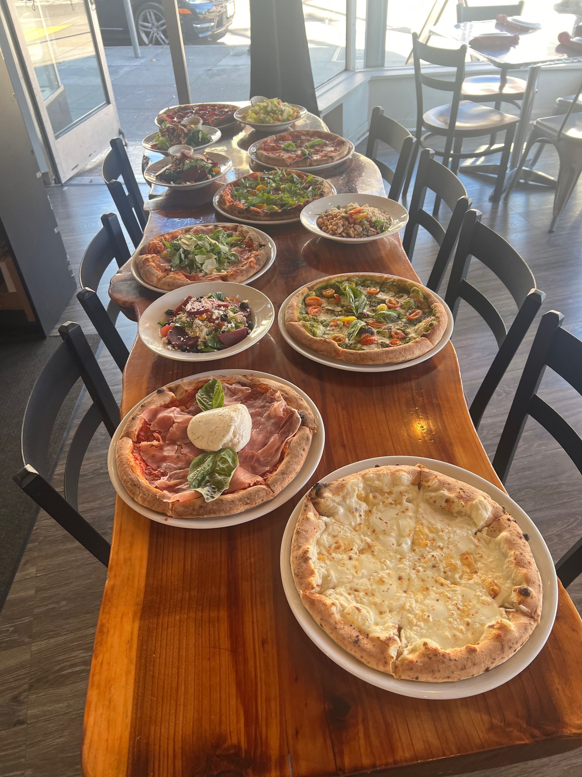 There are many different types of pizzas on the table.