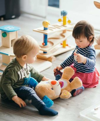 little girl and boy playing with toys by the home 
