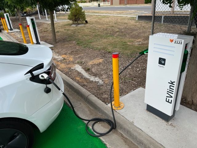a white car is plugged into an evlink charging station