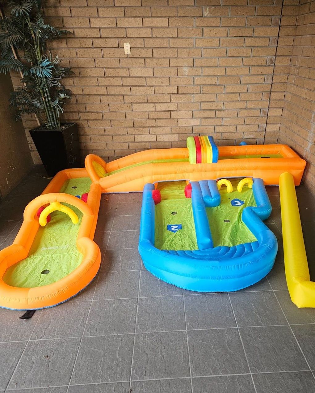 a colorful inflatable water park with a brick wall in the background