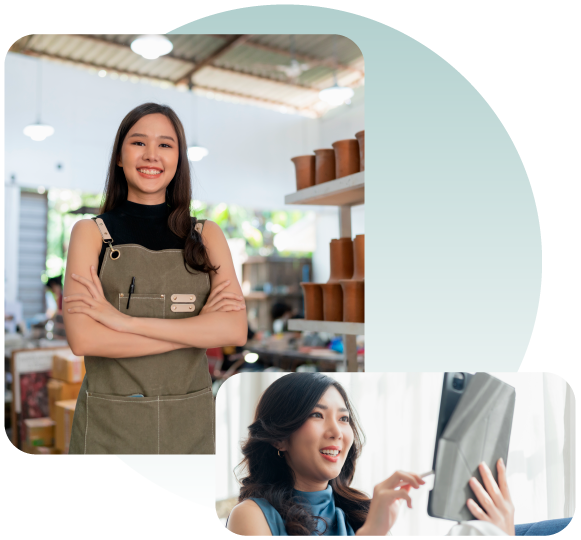 A woman in an apron is standing next to a woman holding a tablet.