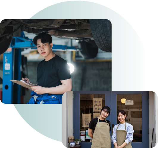 A man is standing under a car and a woman is standing in front of a building.