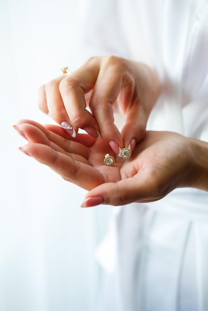 A Woman is Holding a Pair of Earrings in Her Hand — Jimani Trophies & Engraving In Dapto, NSW