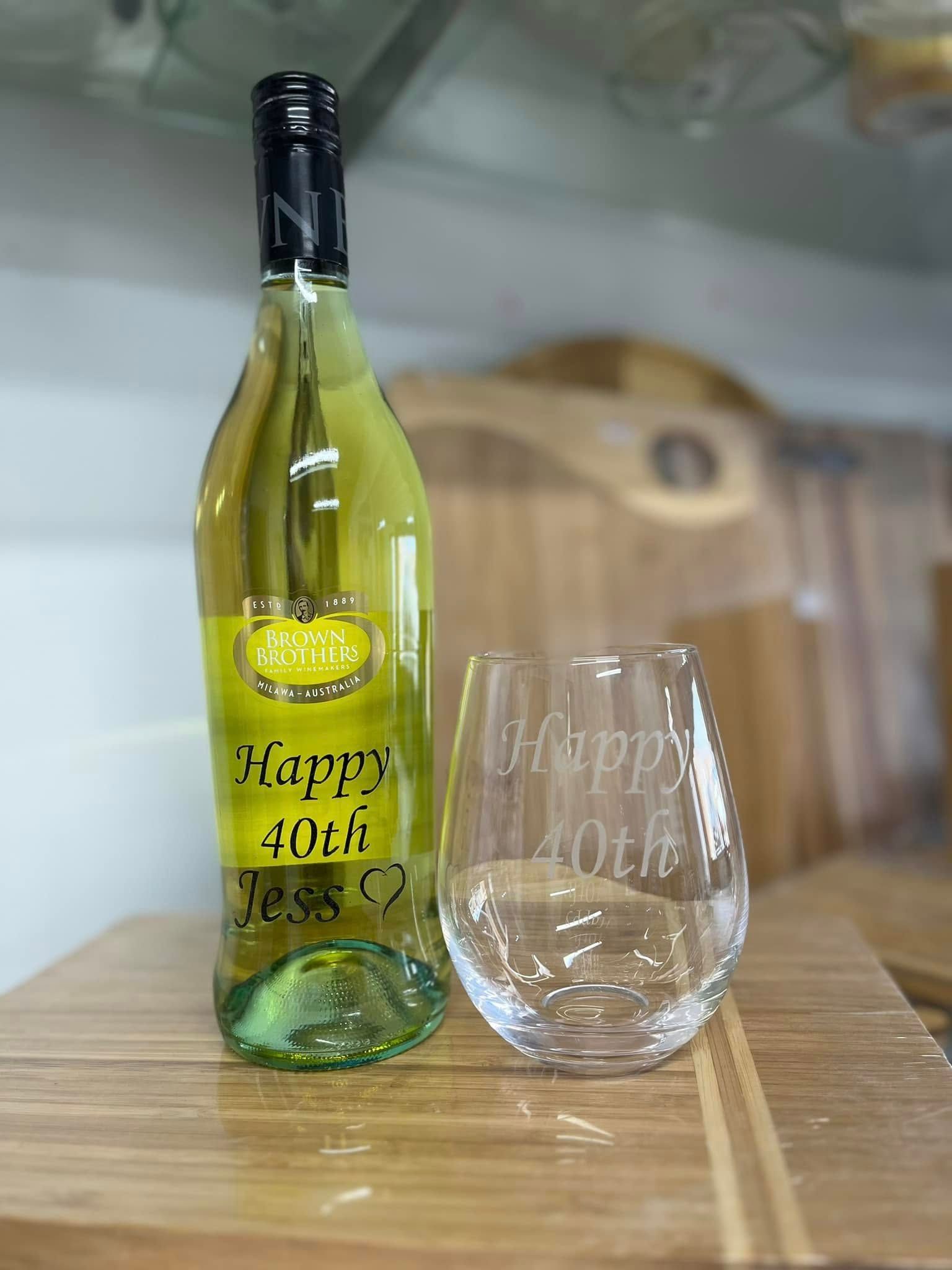 A Bottle of Wine and a Glass on a Wooden Table — Jimani Trophies & Engraving In Dapto, NSW