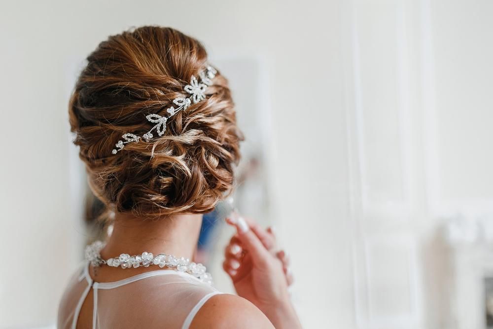 A Woman in a Wedding Dress is Looking at Her Hair in a Mirror — Jimani Trophies & Engraving In Dapto, NSW