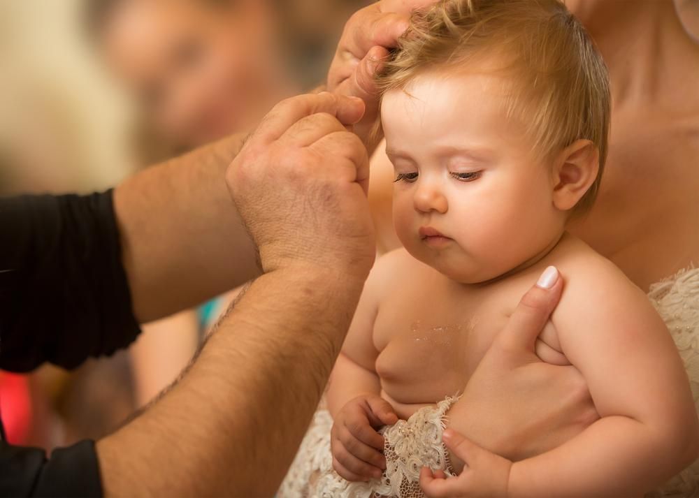 A Woman is Holding a Baby in Her Arms While a Man Brushes Her Hair — Jimani Trophies & Engraving In Dapto, NSW