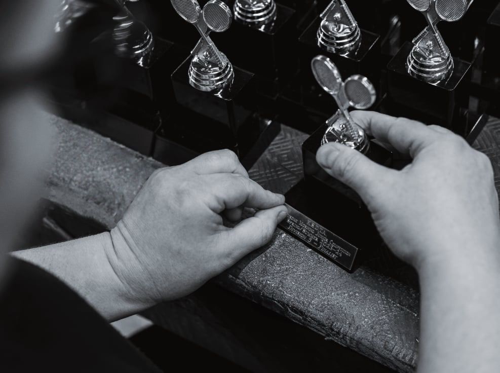 A Black and White Photo of a Person Working on a Spoon — Jimani Trophies & Engraving In Dapto, NSW
