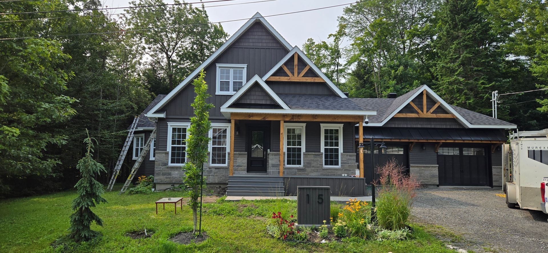 Une grande maison avec beaucoup de fenêtres est entourée d'arbres.