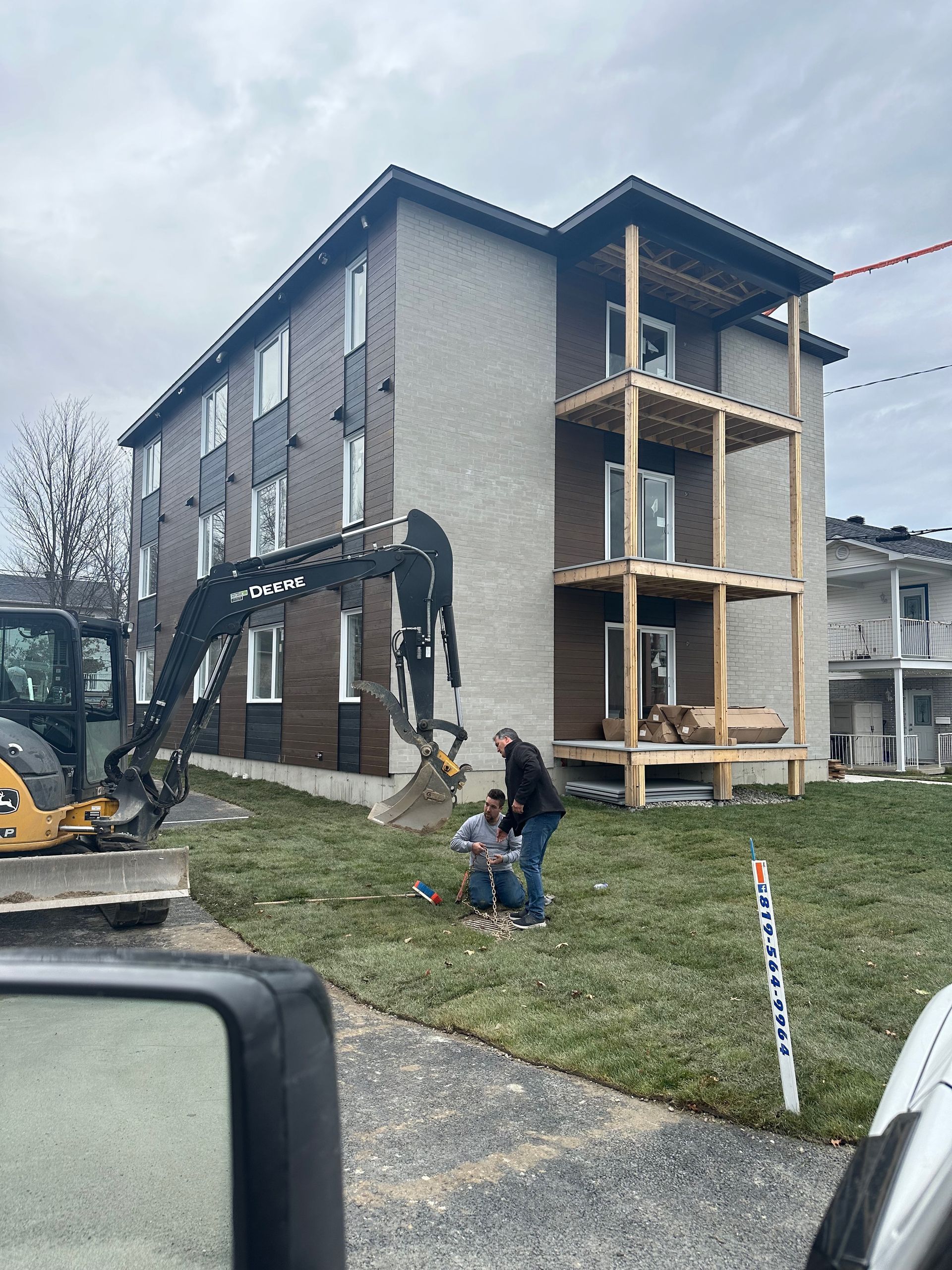 Un homme se tient devant un bâtiment en construction.