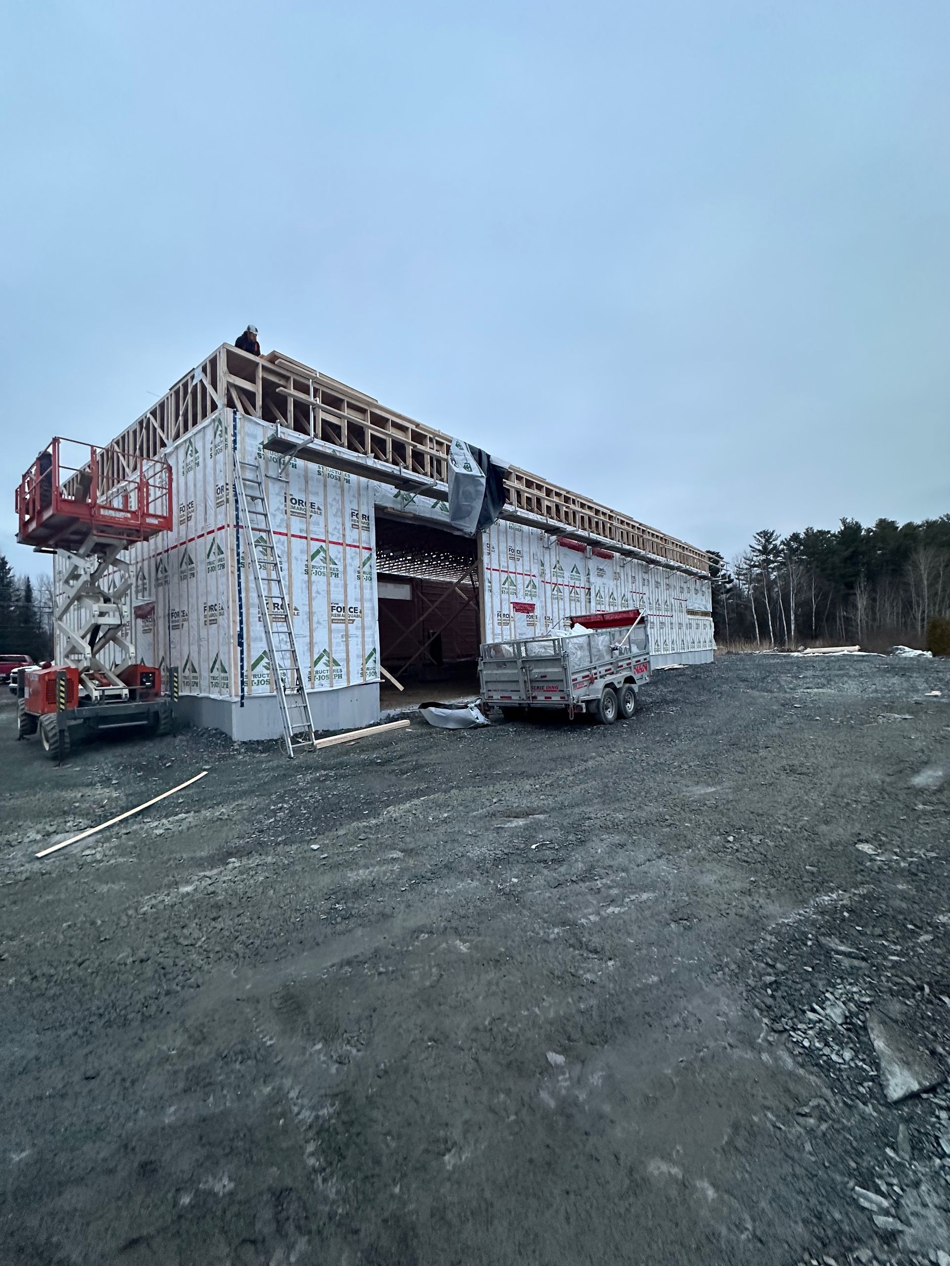 Un grand bâtiment est en construction dans un parking.