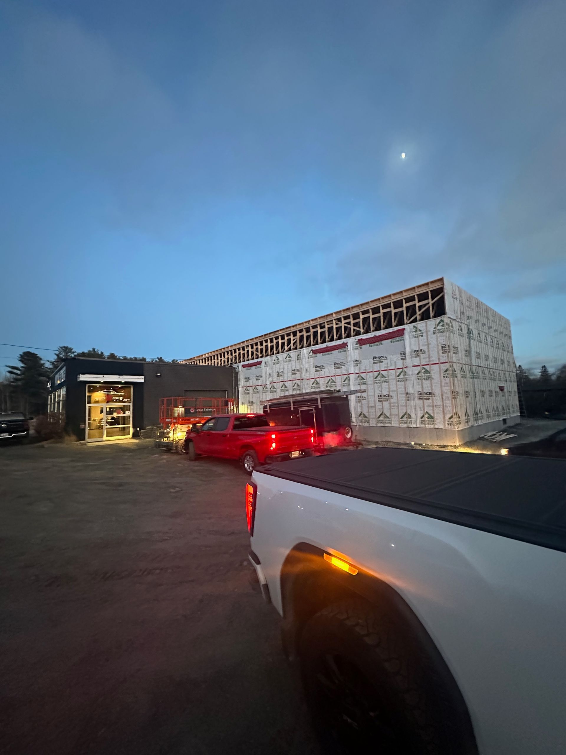 Un camion blanc est garé devant un bâtiment en construction.