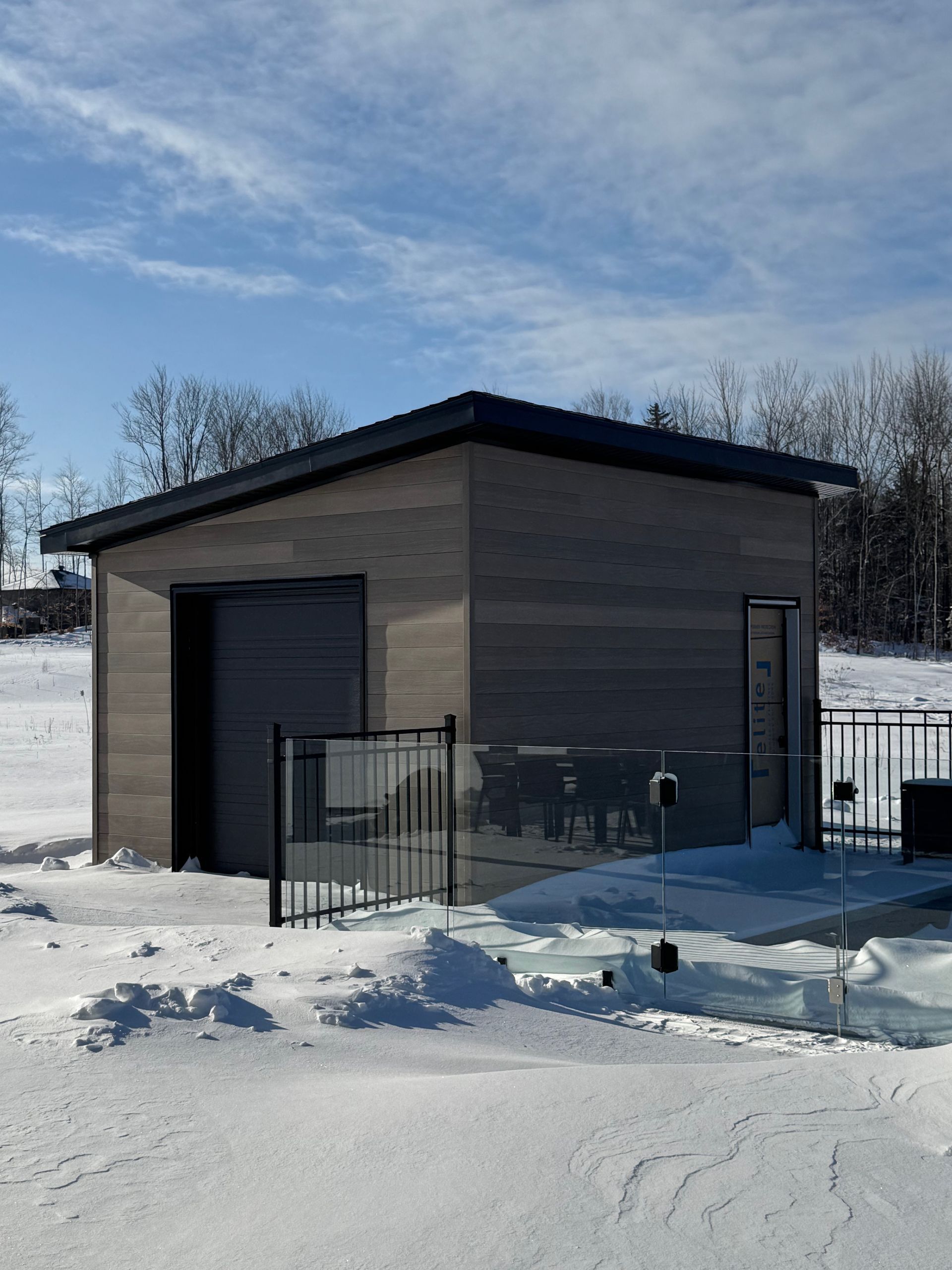 Une petite maison est située au milieu d'un champ enneigé.