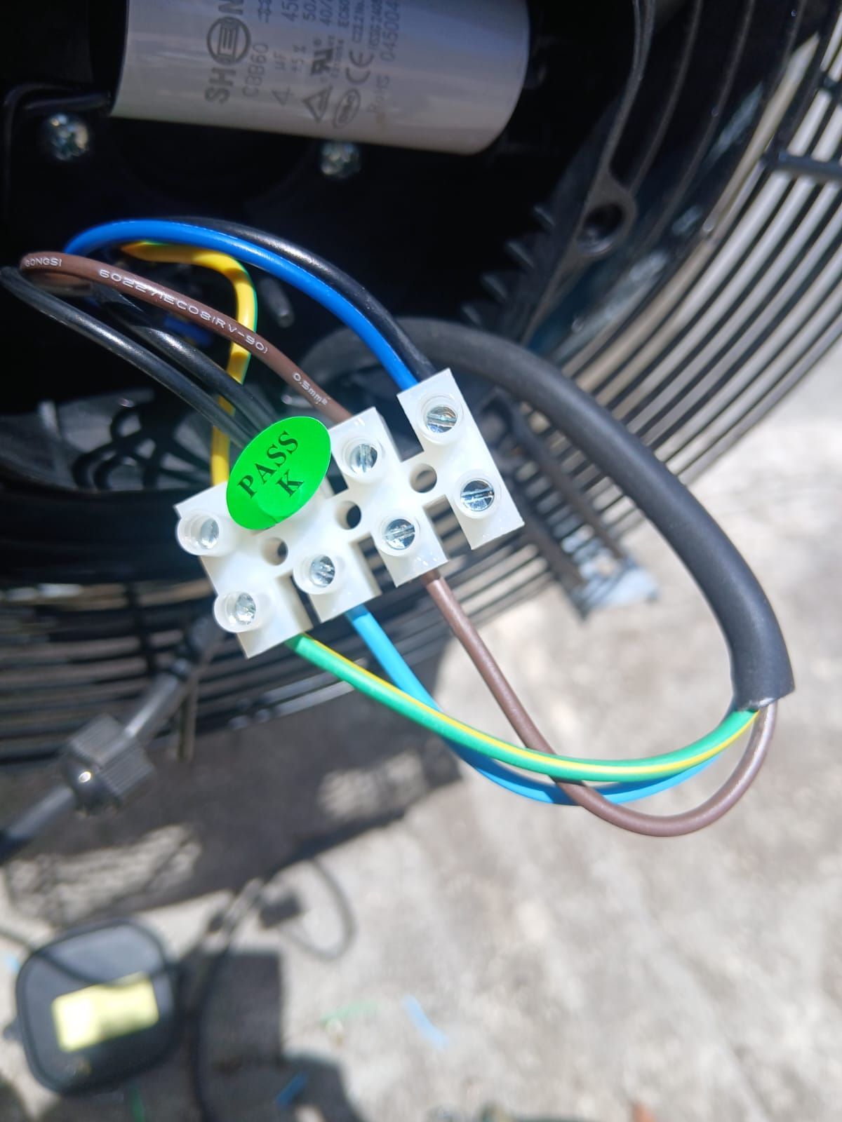 Primer plano del cableado de un ventilador industrial con cables negros, azules, amarillos y marrones.