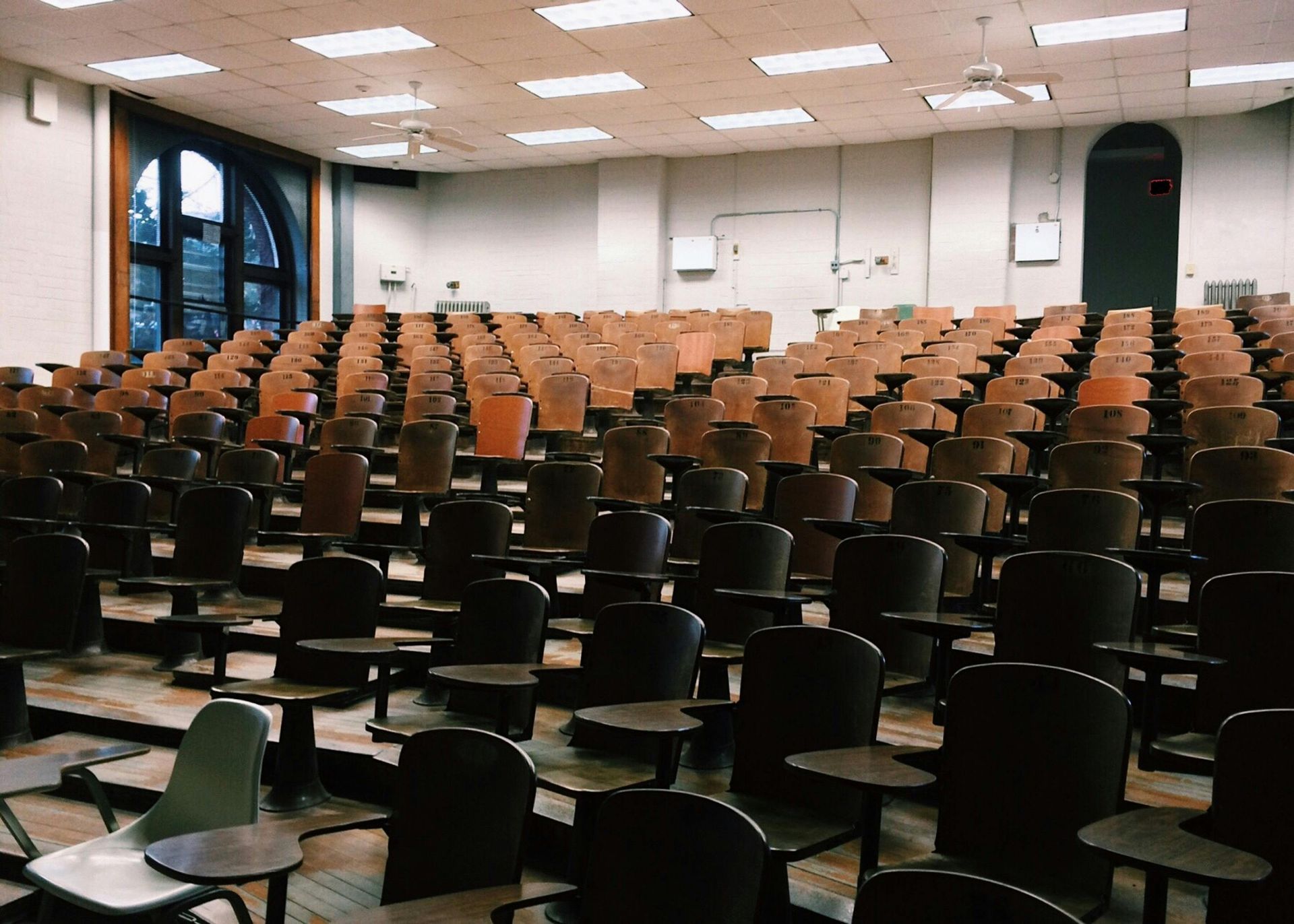 Um auditório vazio com fileiras de cadeiras e mesas