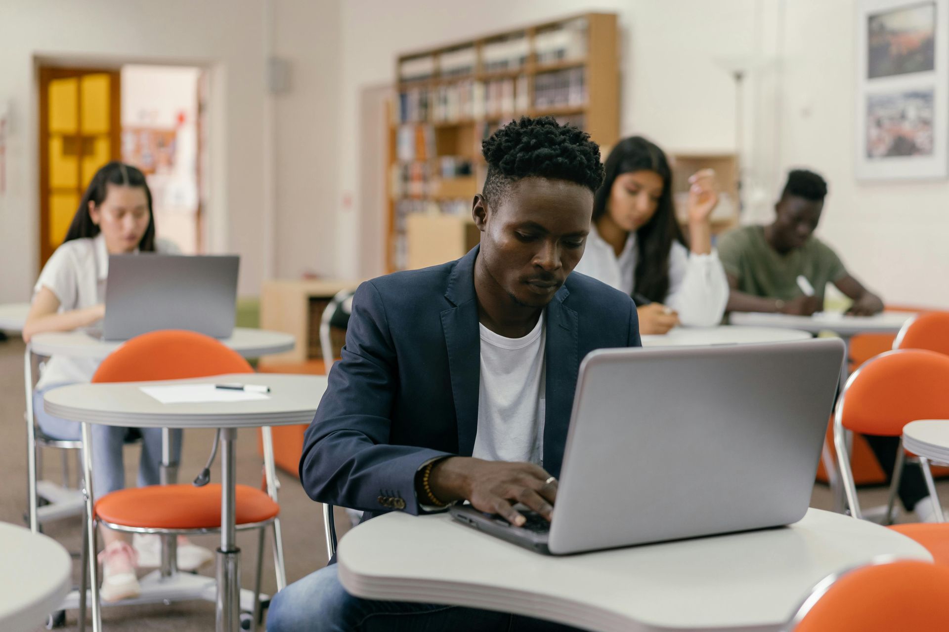 Um homem está sentado à mesa usando um laptop.