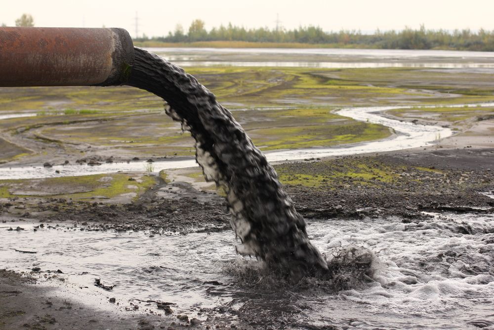 A Pipe Is Pouring Dirty Water Into A River — Liquid Waste Disposal in Wauchope, NSW