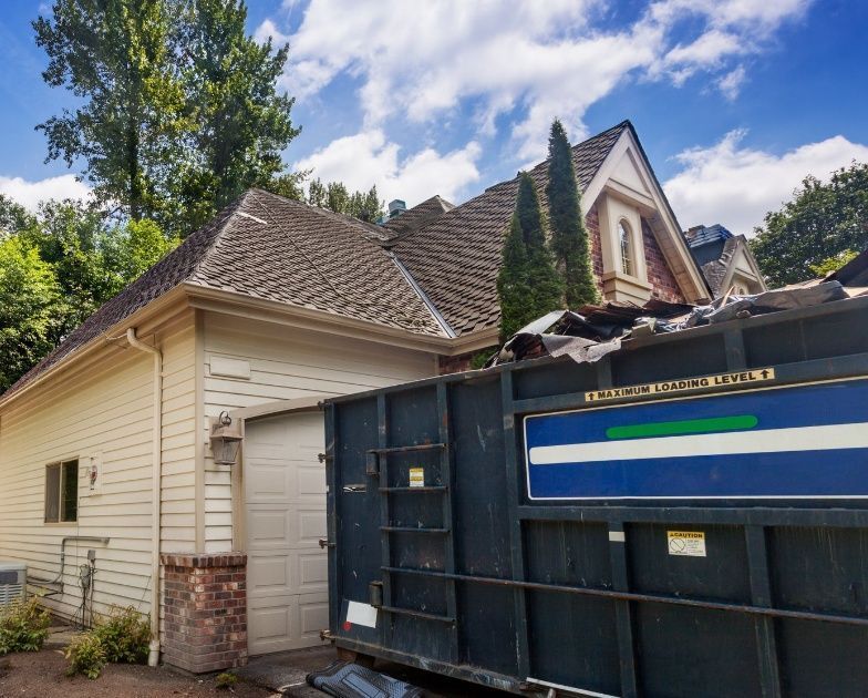 A dumpster is parked in front of a house.