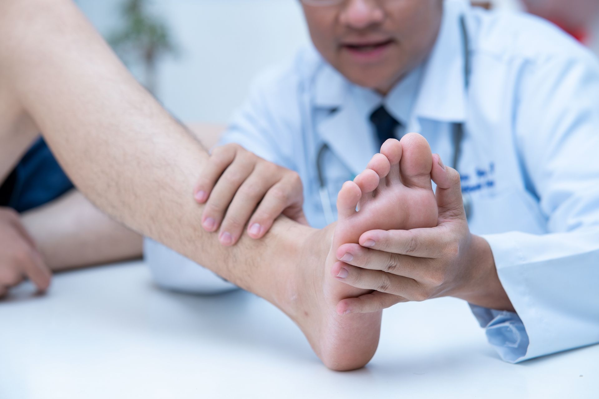 A medical professional inspecting a patient's foot as part of podiatrist services.