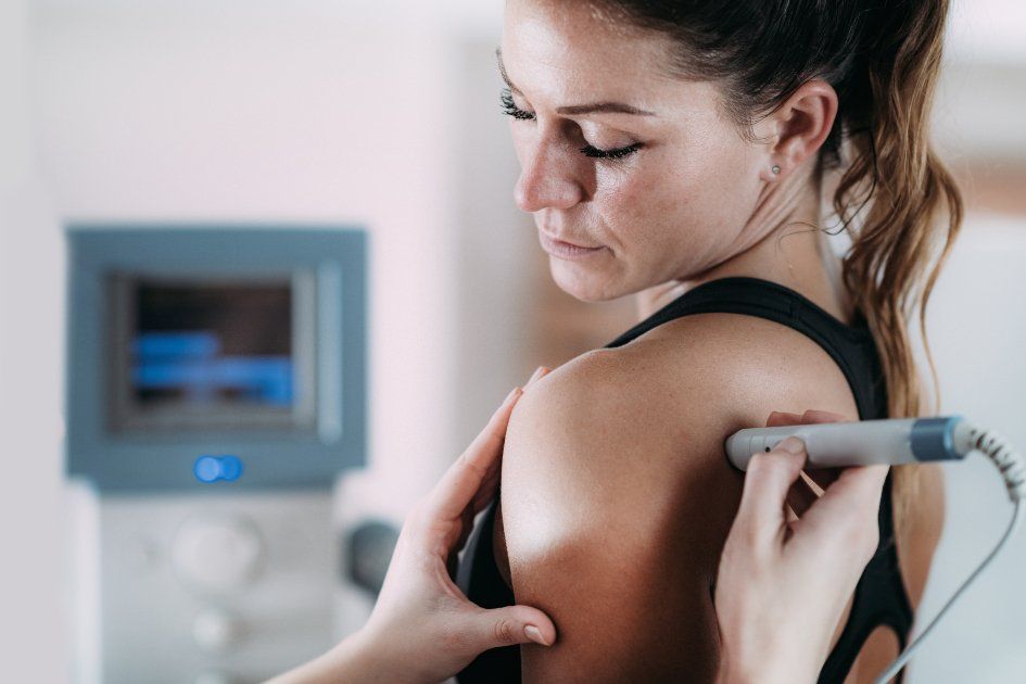 A woman is getting a laser treatment on her shoulder.