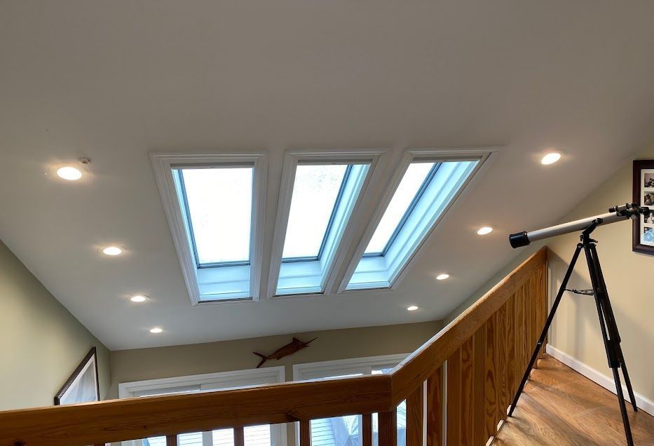 A staircase with a telescope and skylights on the ceiling
