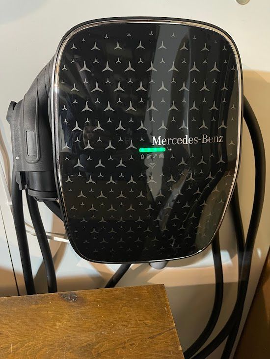 A mercedes benz charger is plugged into a wall