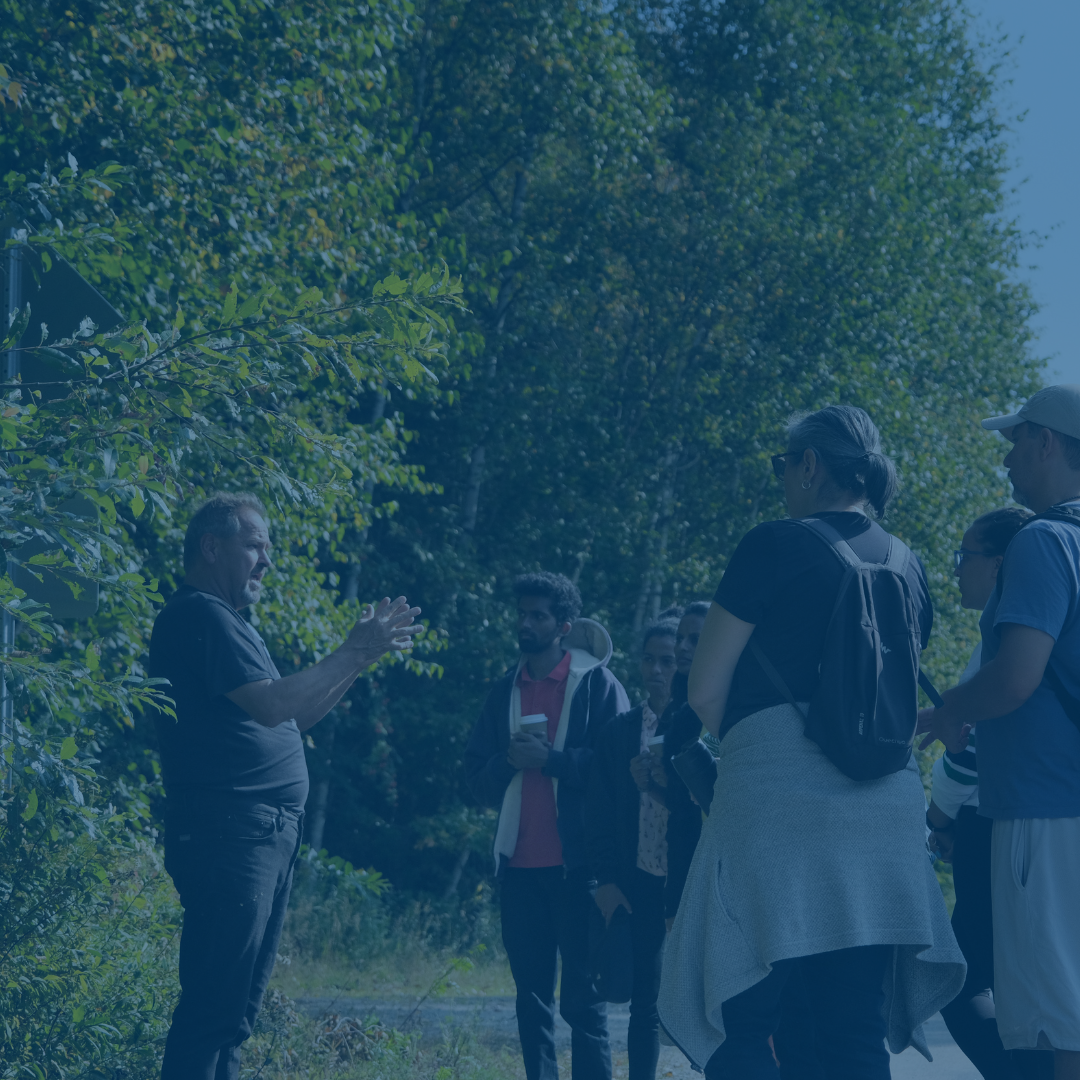 A group of students standing outside with a professor.