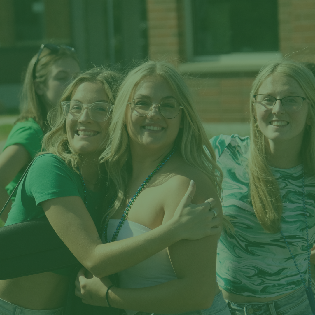 3 girls hugging and smiling for the camera.