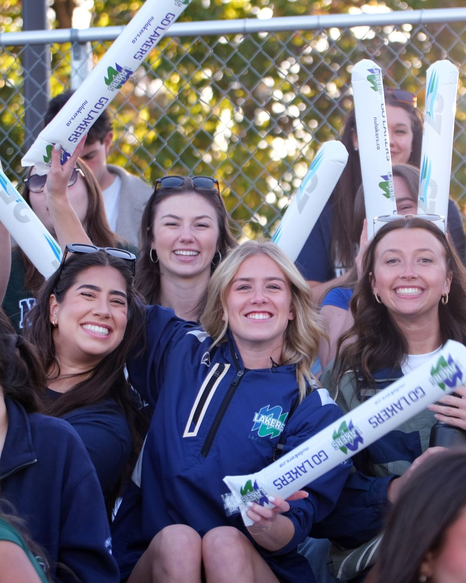 A group of students and parents cheering for the camera