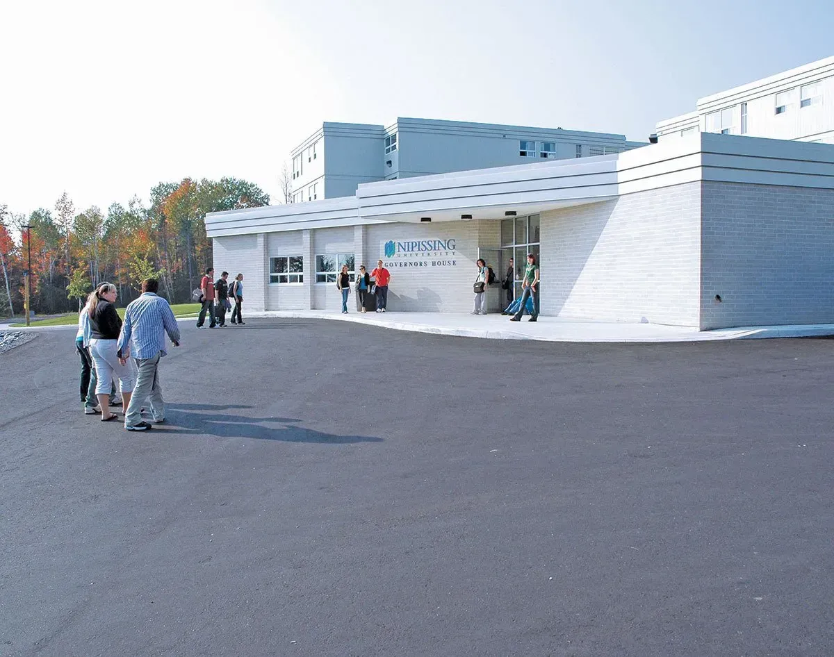 A group of people are walking in front of a building.