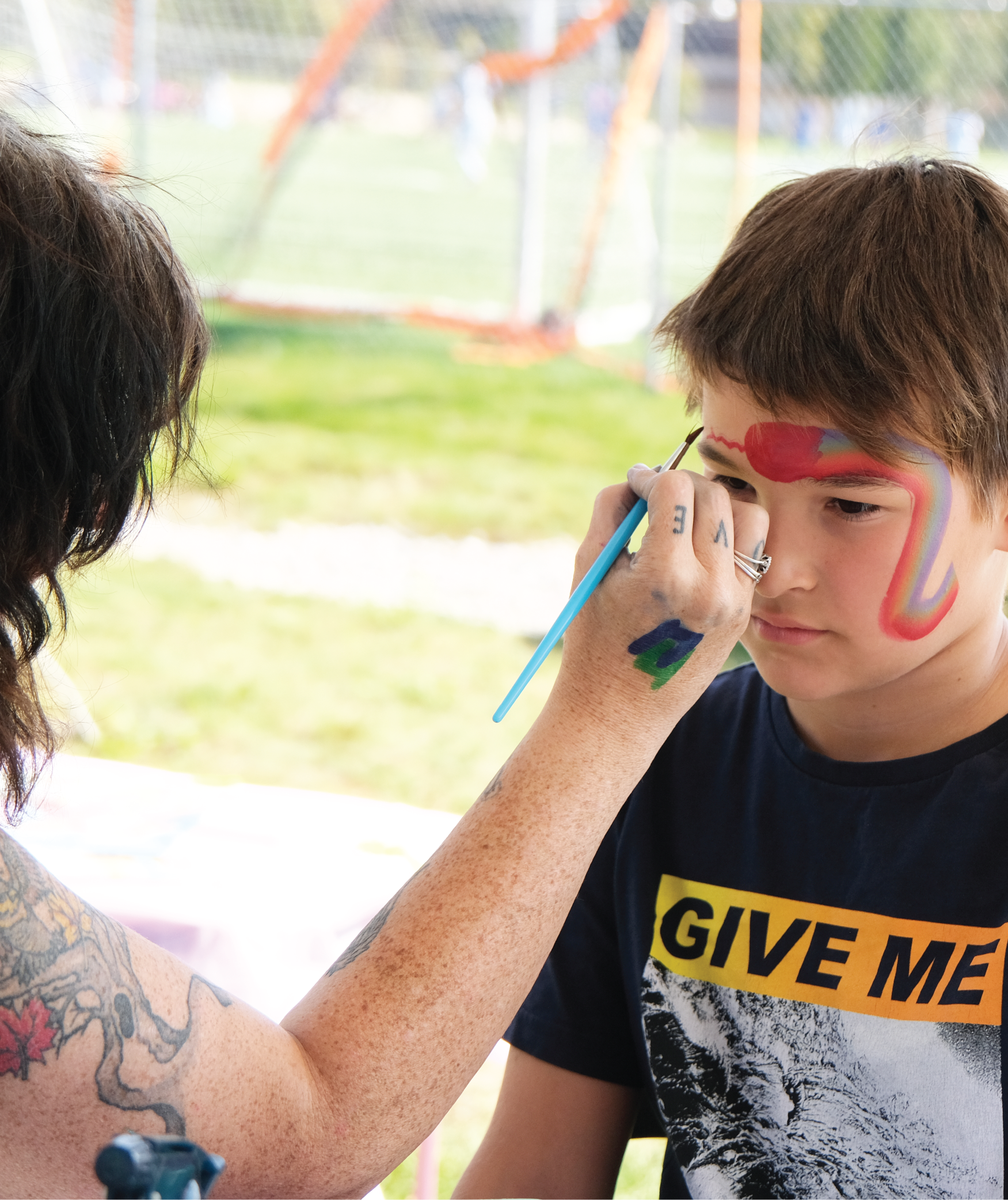 A boy getting face-painted by an artist