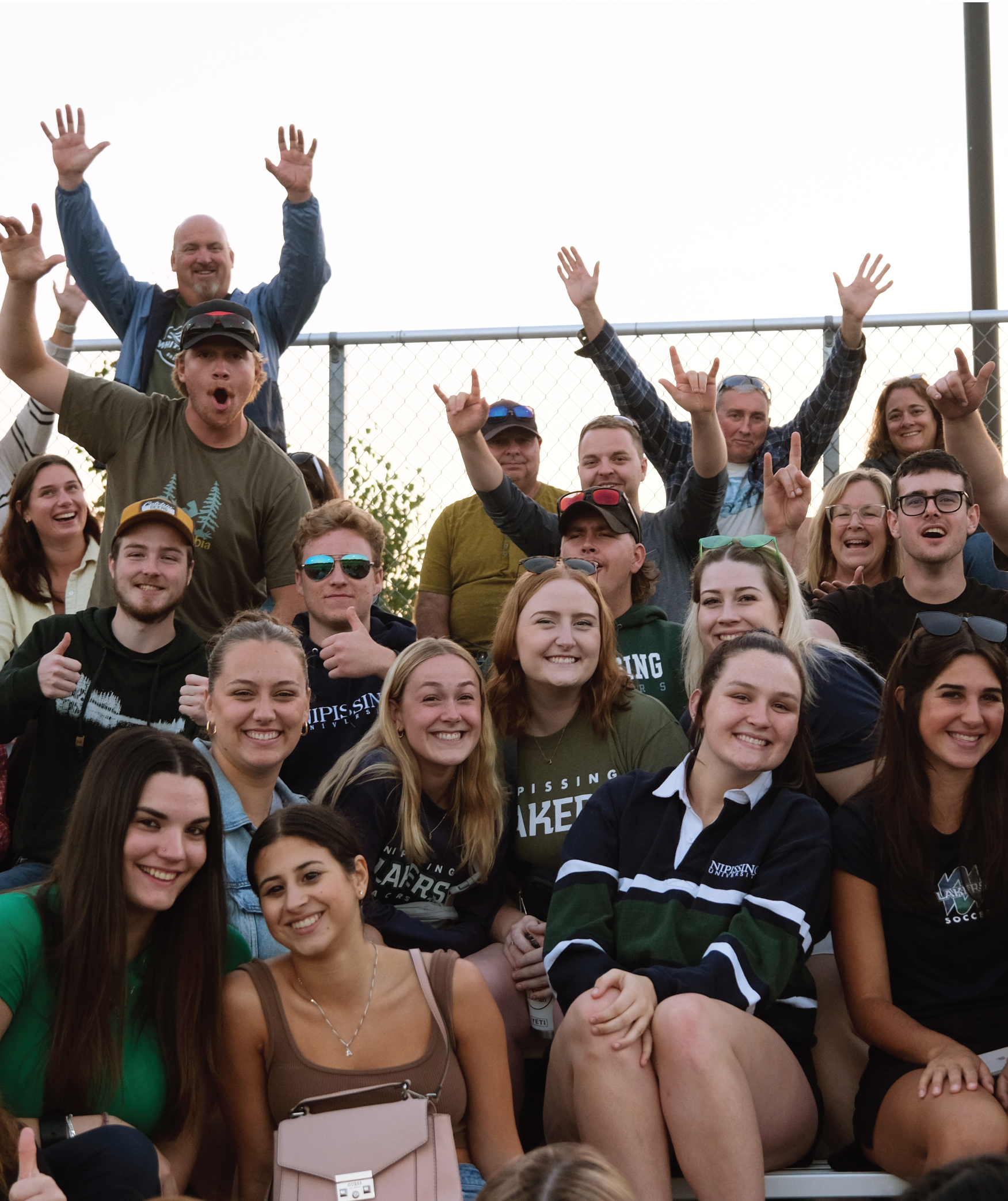 A group of students and parents cheering for the camera