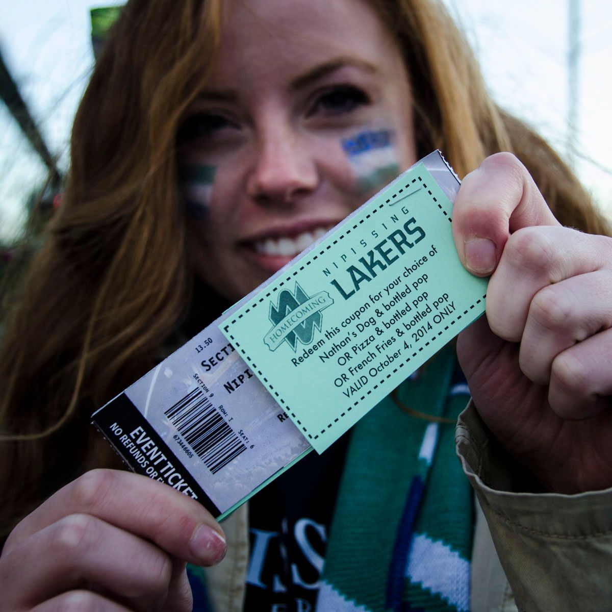 A woman is holding a Lakers ticket in her hand