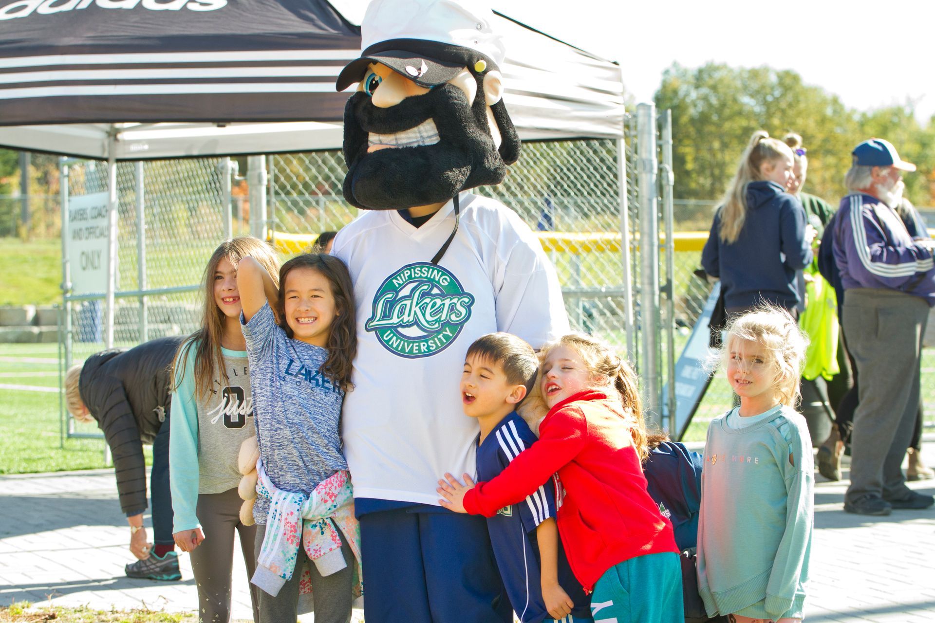 5 kids standing next to the Lakers Mascot and taking pictures