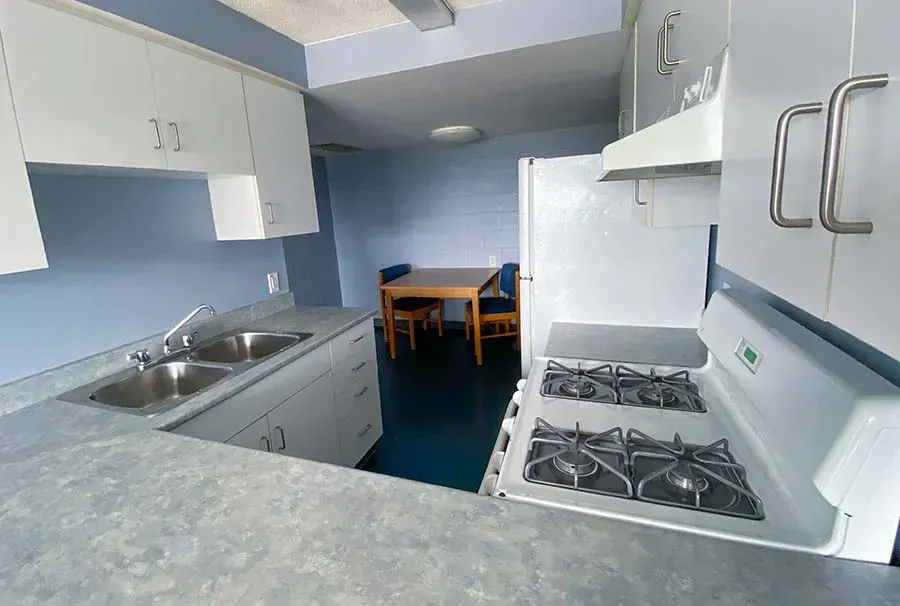 A kitchen with a stove , sink , and refrigerator