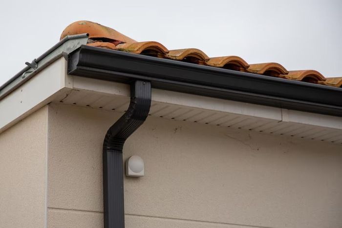 A close up of a gutter on the side of a building.