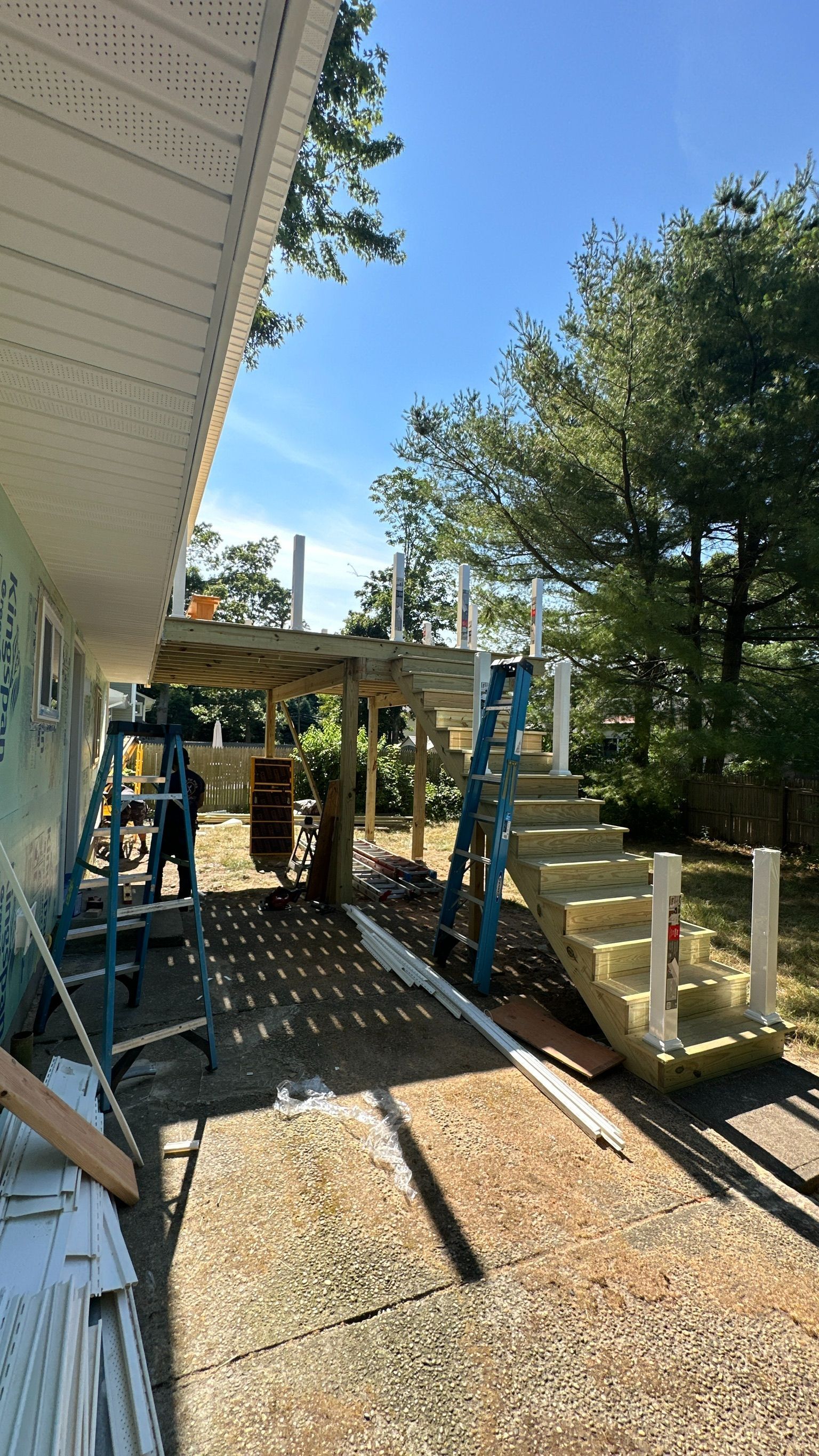 A wooden deck is being built on the side of a house.