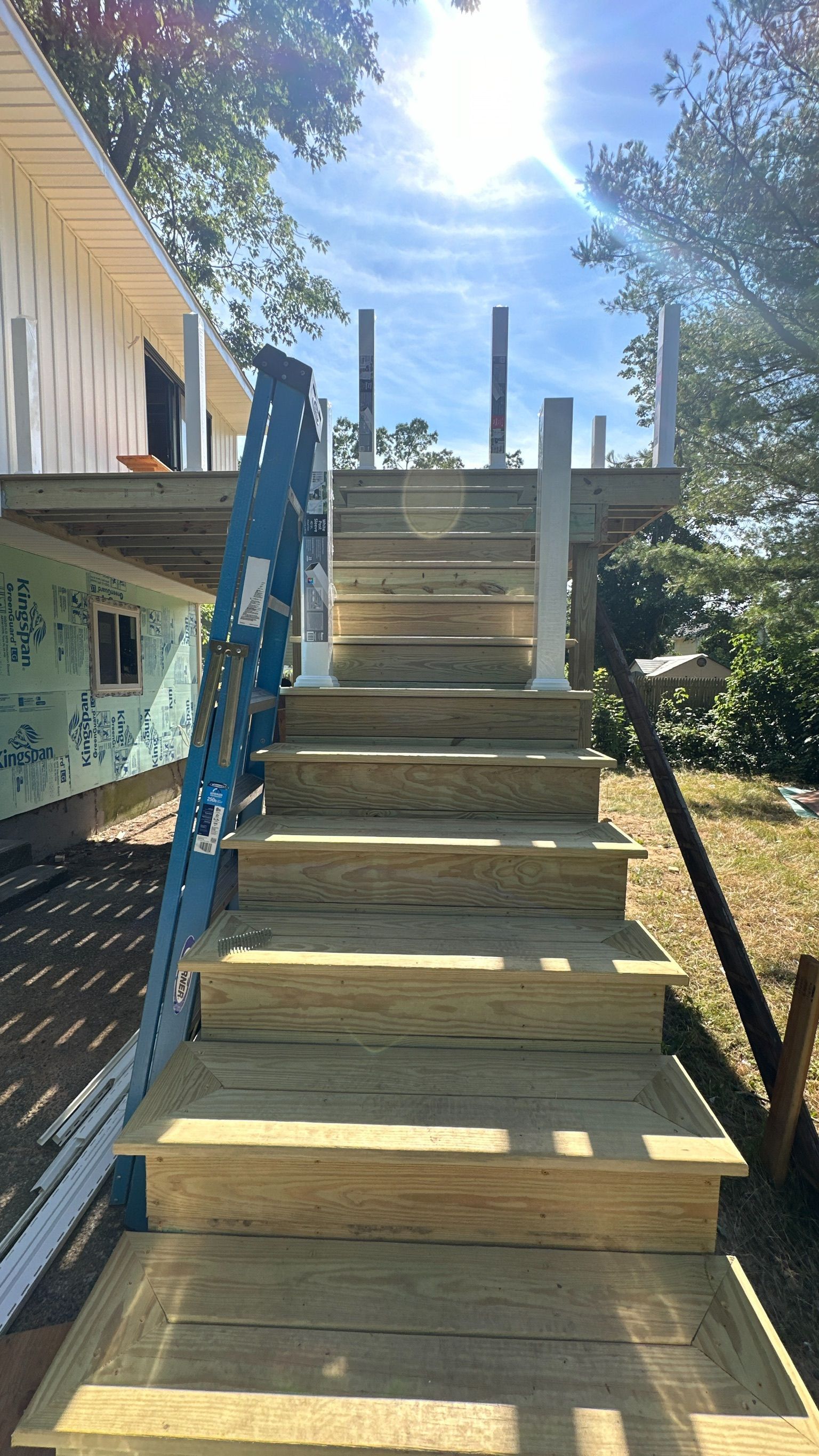 A set of wooden stairs leading up to a deck under construction.