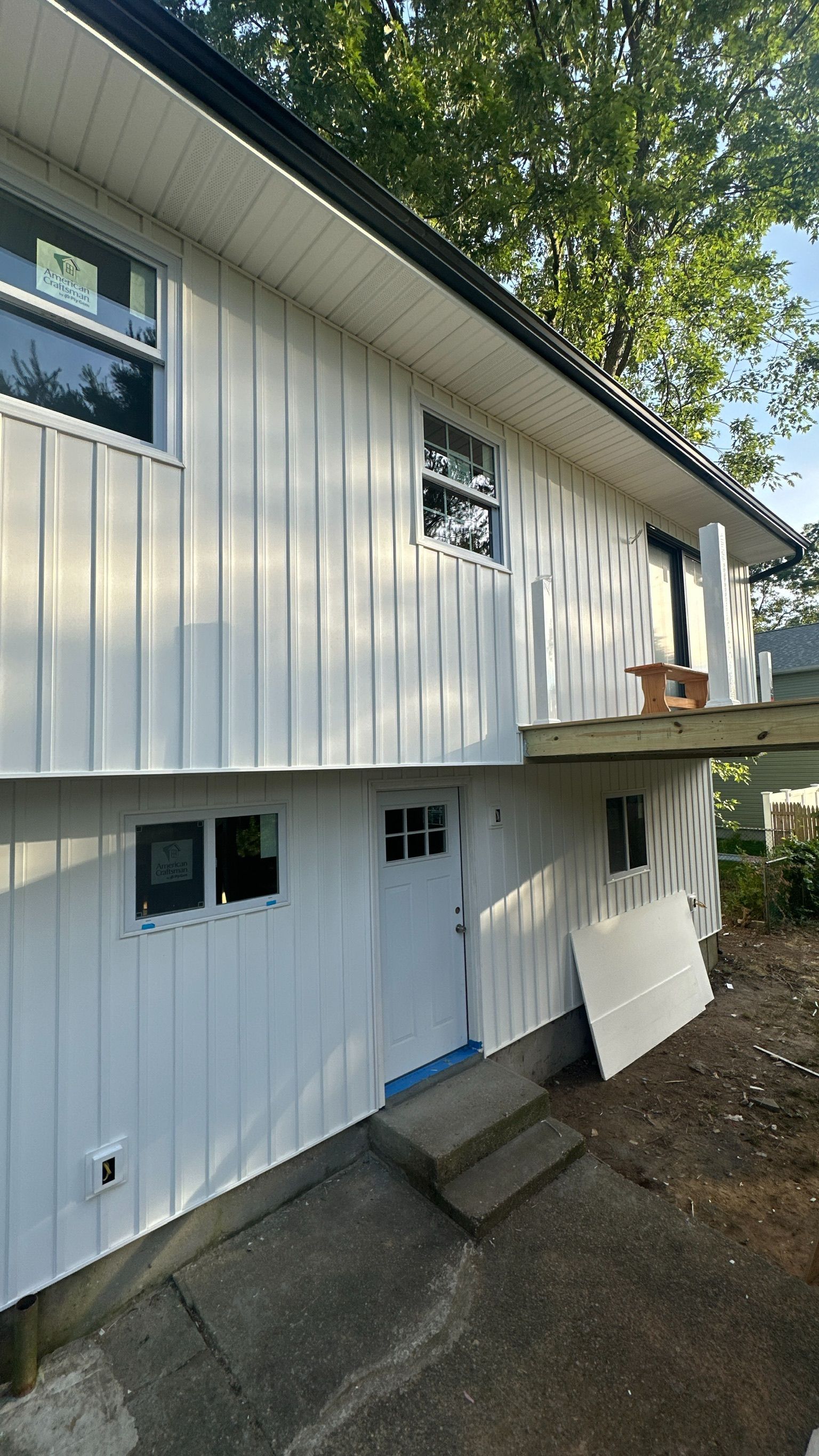 A white house with a balcony and stairs on the side of it.