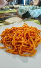 Un primo piano di un piatto di spaghetti al sugo di pomodoro su un tavolo.